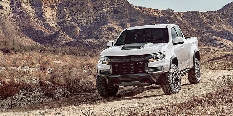 Image of white 4x4 Chevrolet truck driving on the rocks and mountains