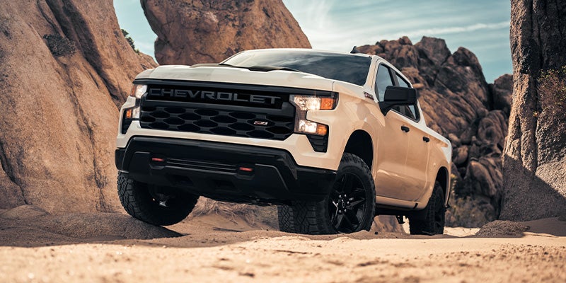 Image of white 4x4 Chevrolet truck driving on the rocks and mountains