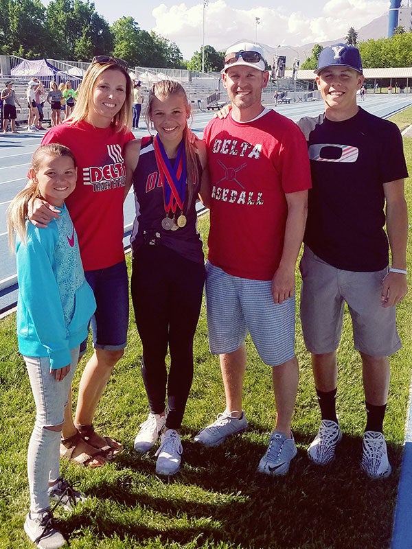 Image of Brady Nielson and his family standing and smiling near a race track