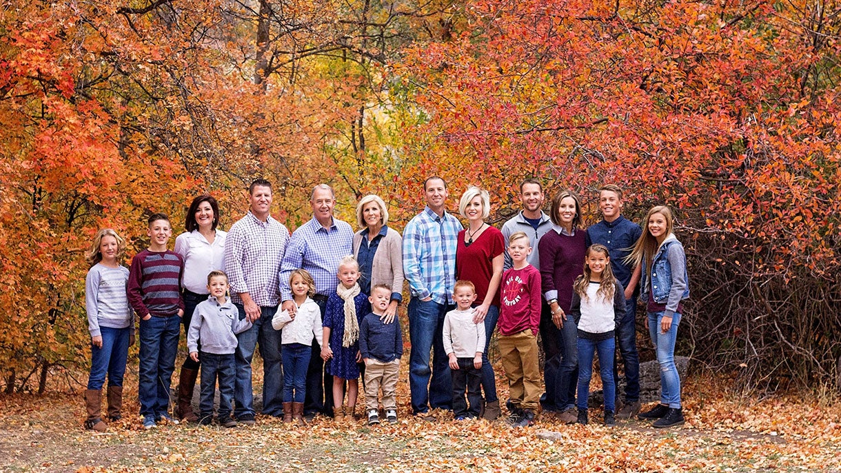 Image of Rob Droubay and his family standing in front of beautiful and fall color trees
